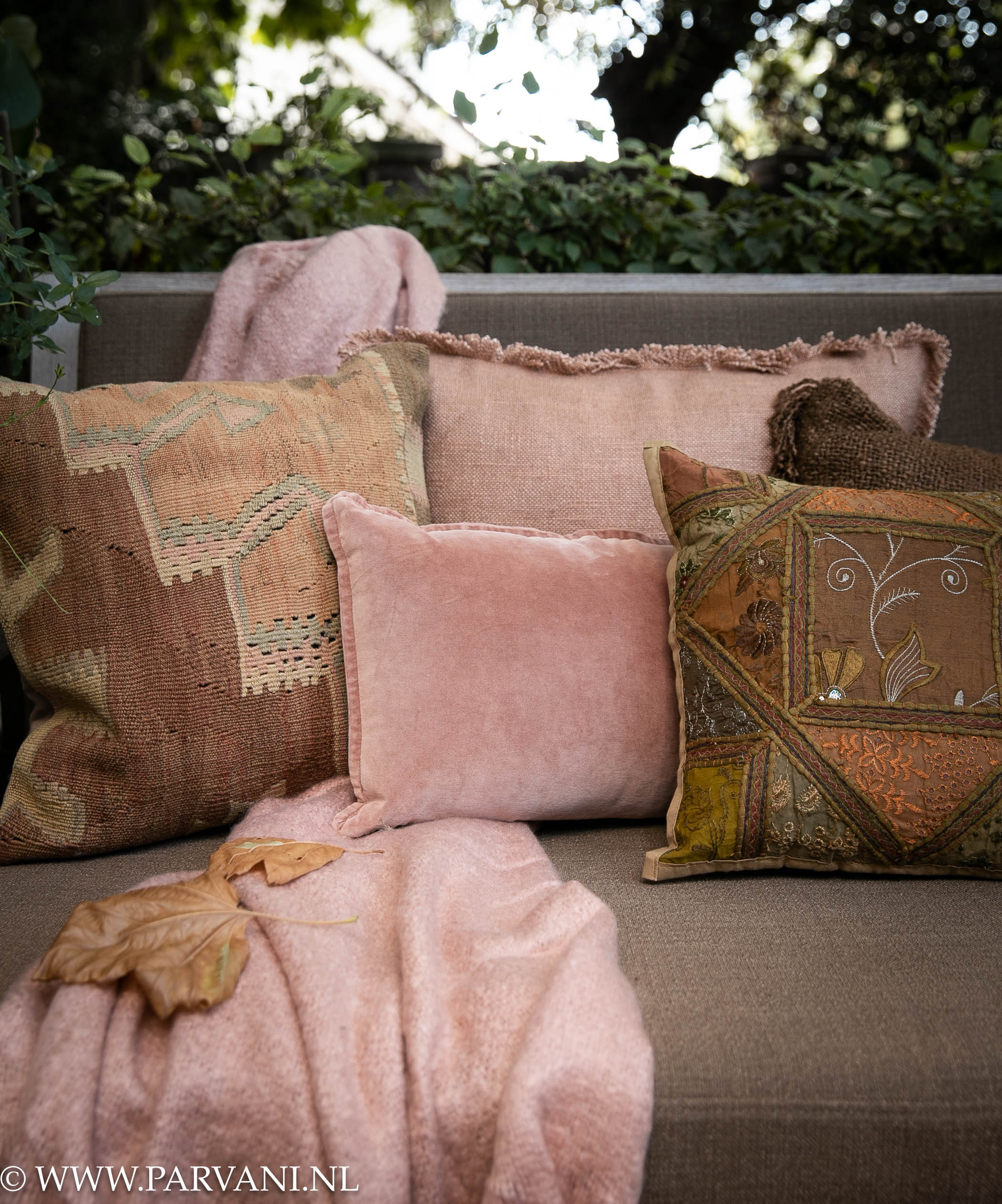 Kussens en plaid met kelim, velvet en grove linnen in warme roze, bruin en groene kleuren