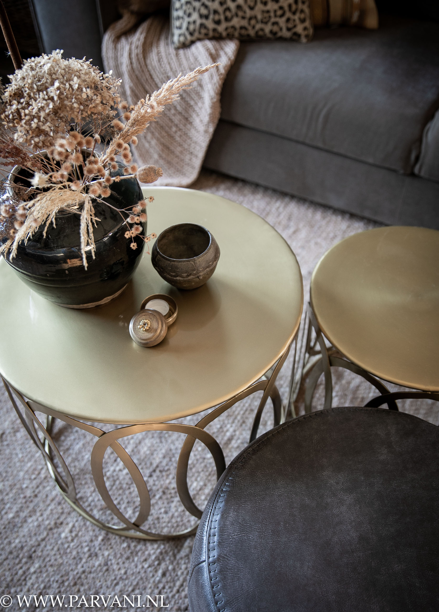 goudkleurige ronde bijzet salontafels met opengewerkte zijkant en grijze ronde leren poef