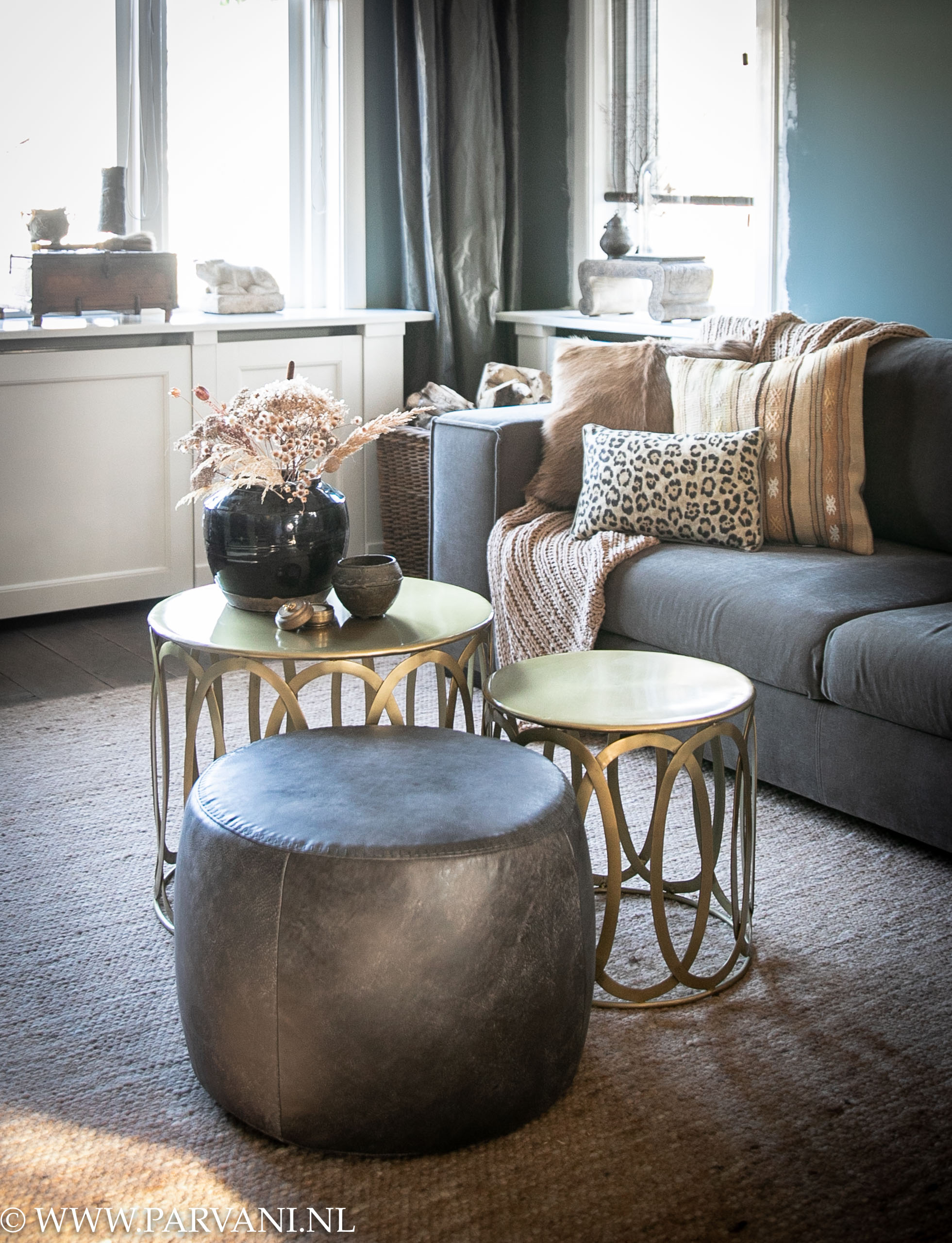 goudkleurige ronde bijzet salontafels met opengewerkte zijkant en grijze ronde leren poef