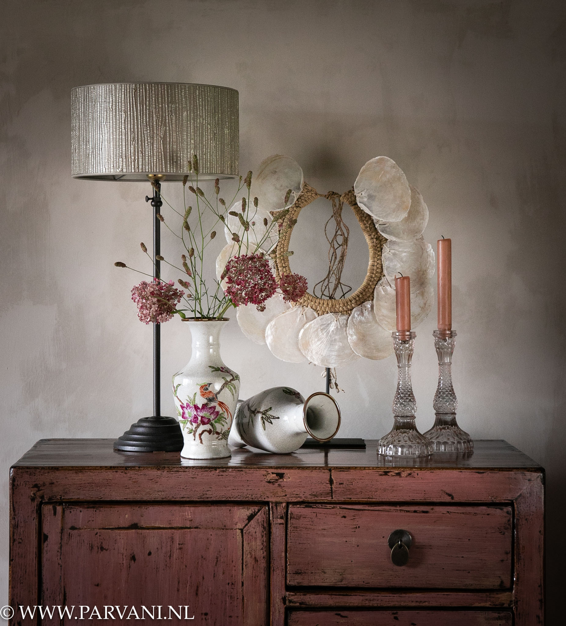 Accessoires in frisse lichte tinten op roze kastje, met schelpenketting, Chinese vaasjes en tafellamp met luxe lampenkap