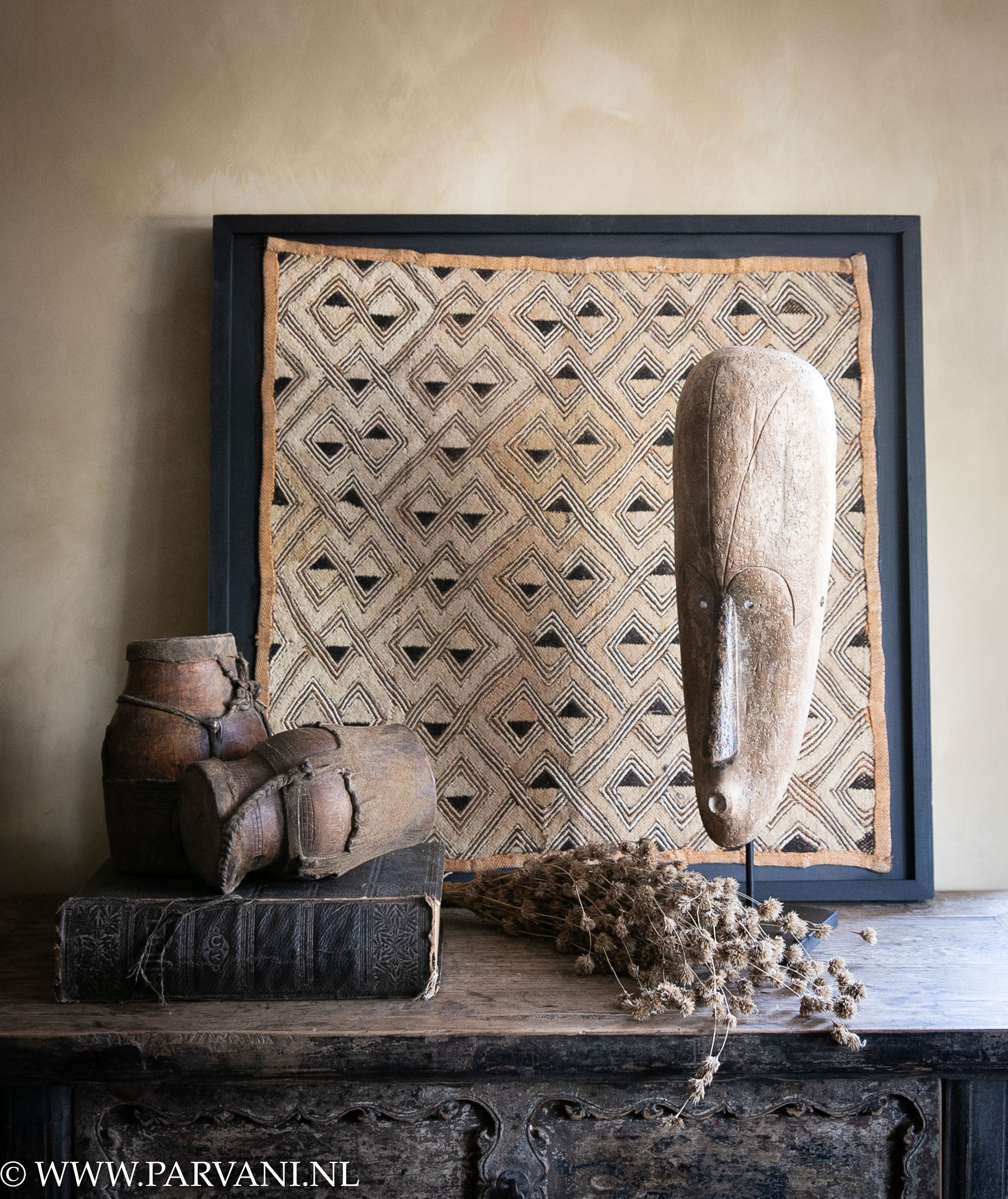 Afrikaanse woonaccessoires, houten masker, lederen bekers en ingelijst textiel Kuba cloth camel geel bruin zwarte tinten