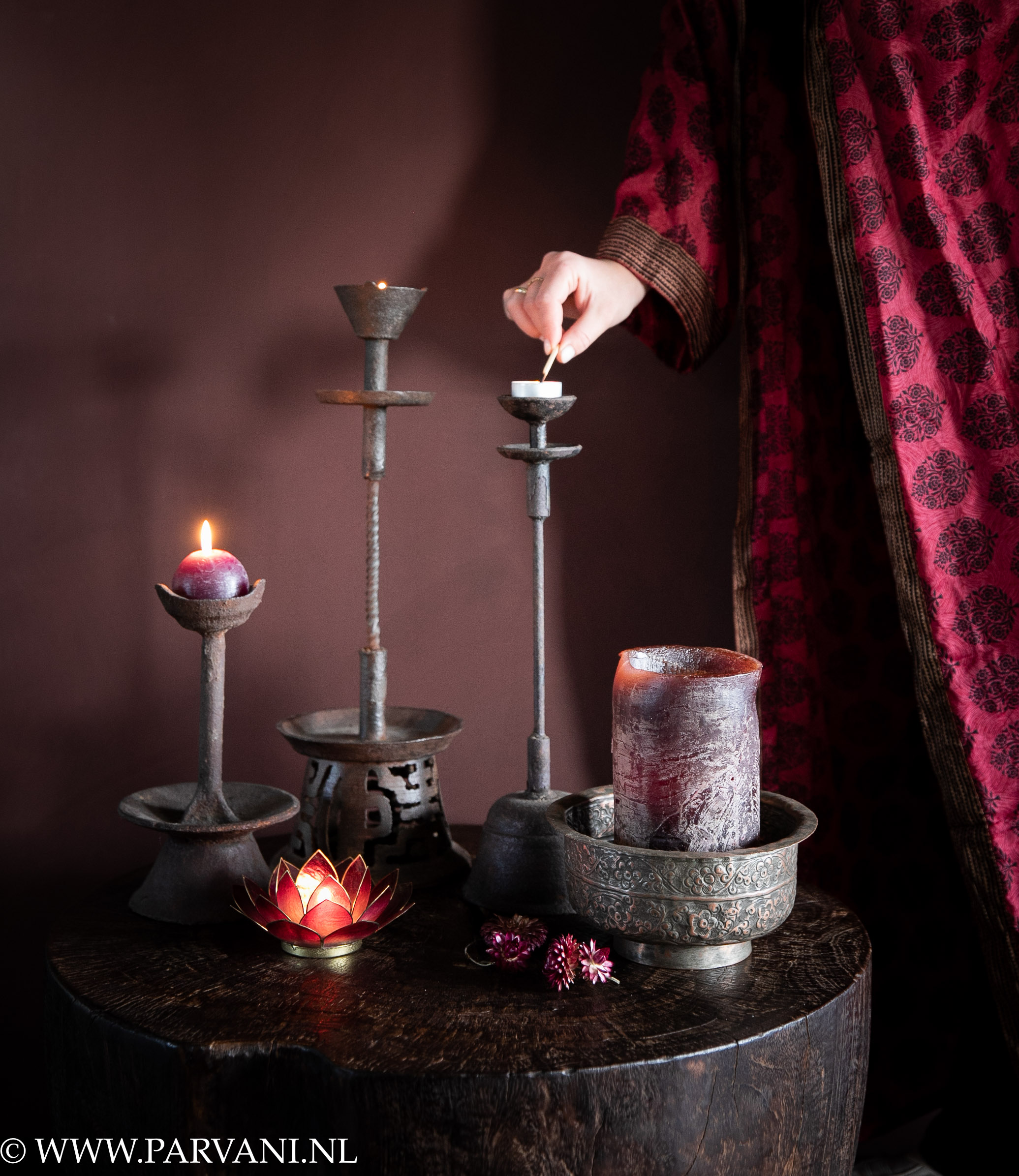 Bruine smeedijzeren kandelaren uit China, oud koperen schaaltje uit India met aubergine paarse kaarsen en zijde kimono