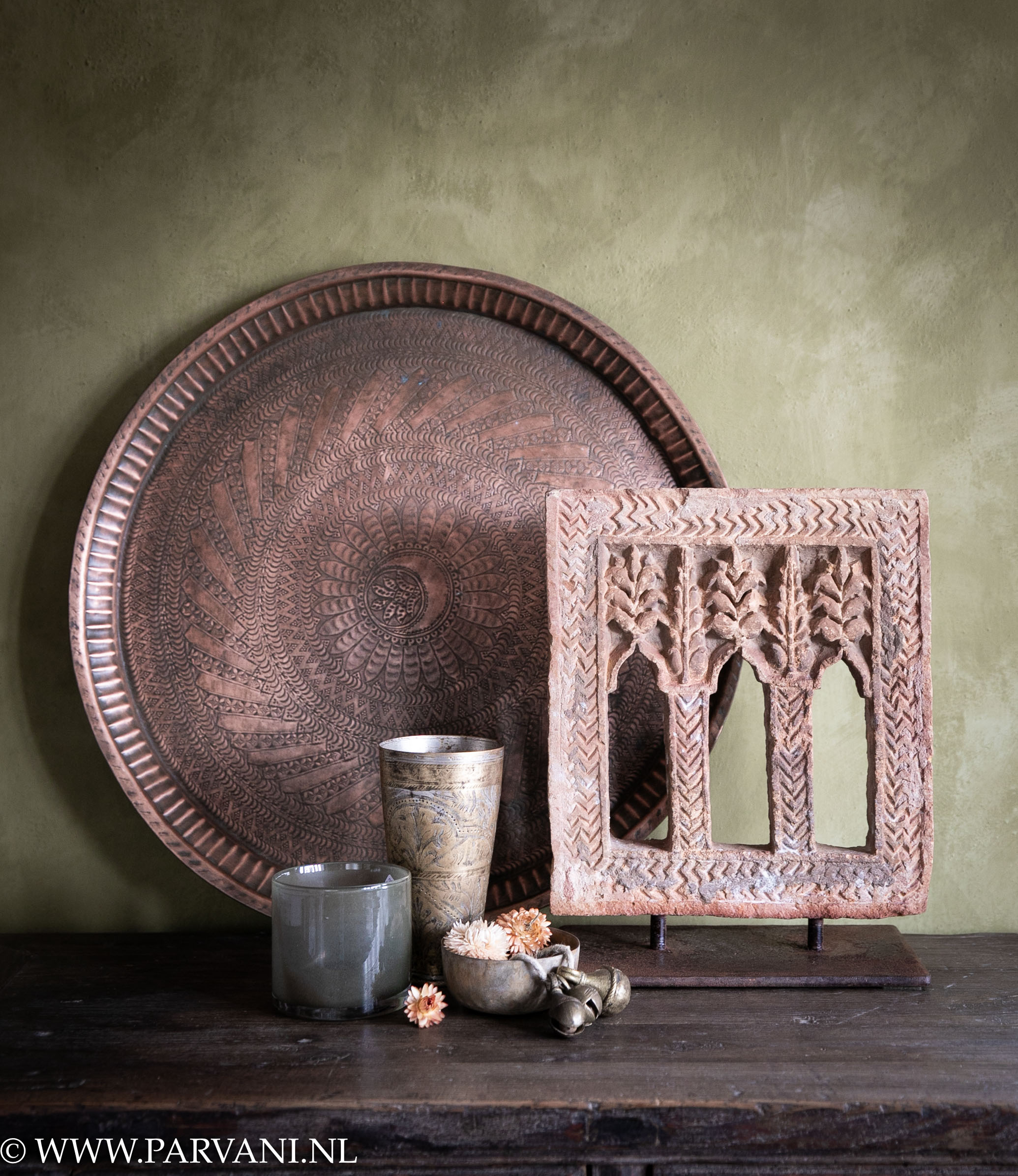 Decoratief stenen ornament op standaard uit India met grote ronde koperen schaal- dienblad, messing schaaltjes en oude bruidsbeker