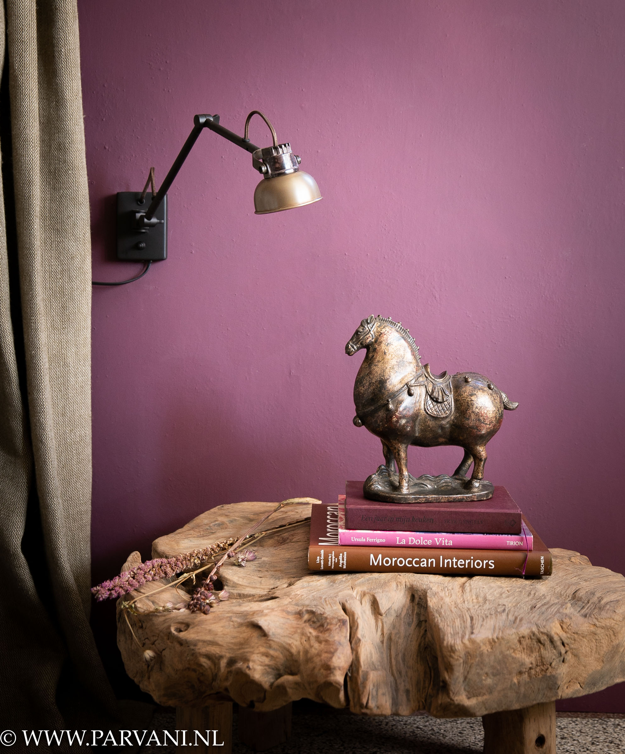 Koperen wandlamp Mazz met knikarm en uniek bronzen paard op grillige houten bijzettafel