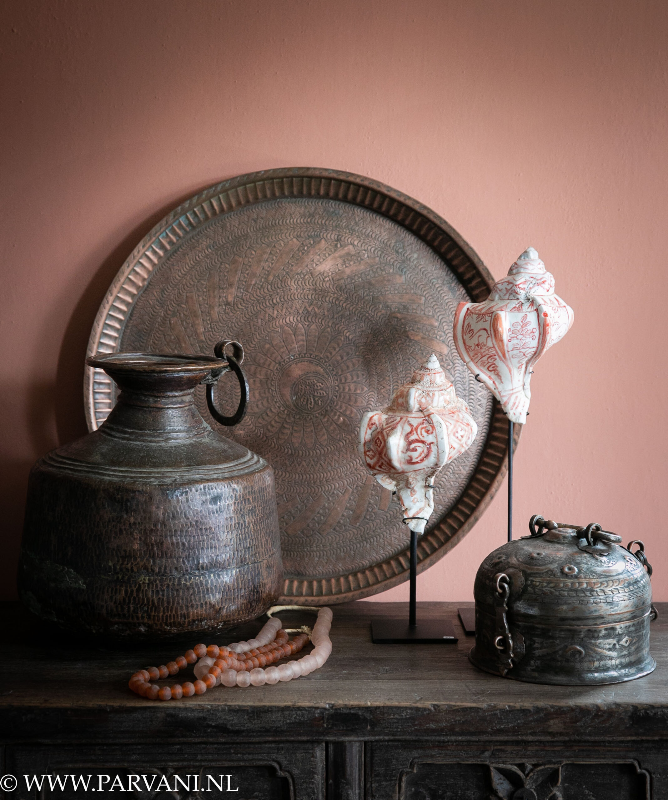 Oud rond koperen dienblad met gravering, bewerkte unieke koperen vaas en paanbox met set beschilderde schelpen op standaard