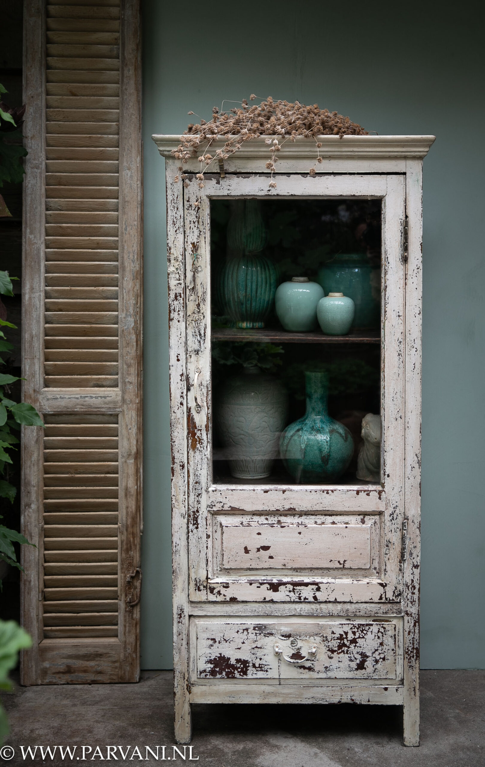 Smal oud houten vitrinekastje glaskast uit India met donkere binnenzijde en creme kleurige buitenkant met blauw groene vazen