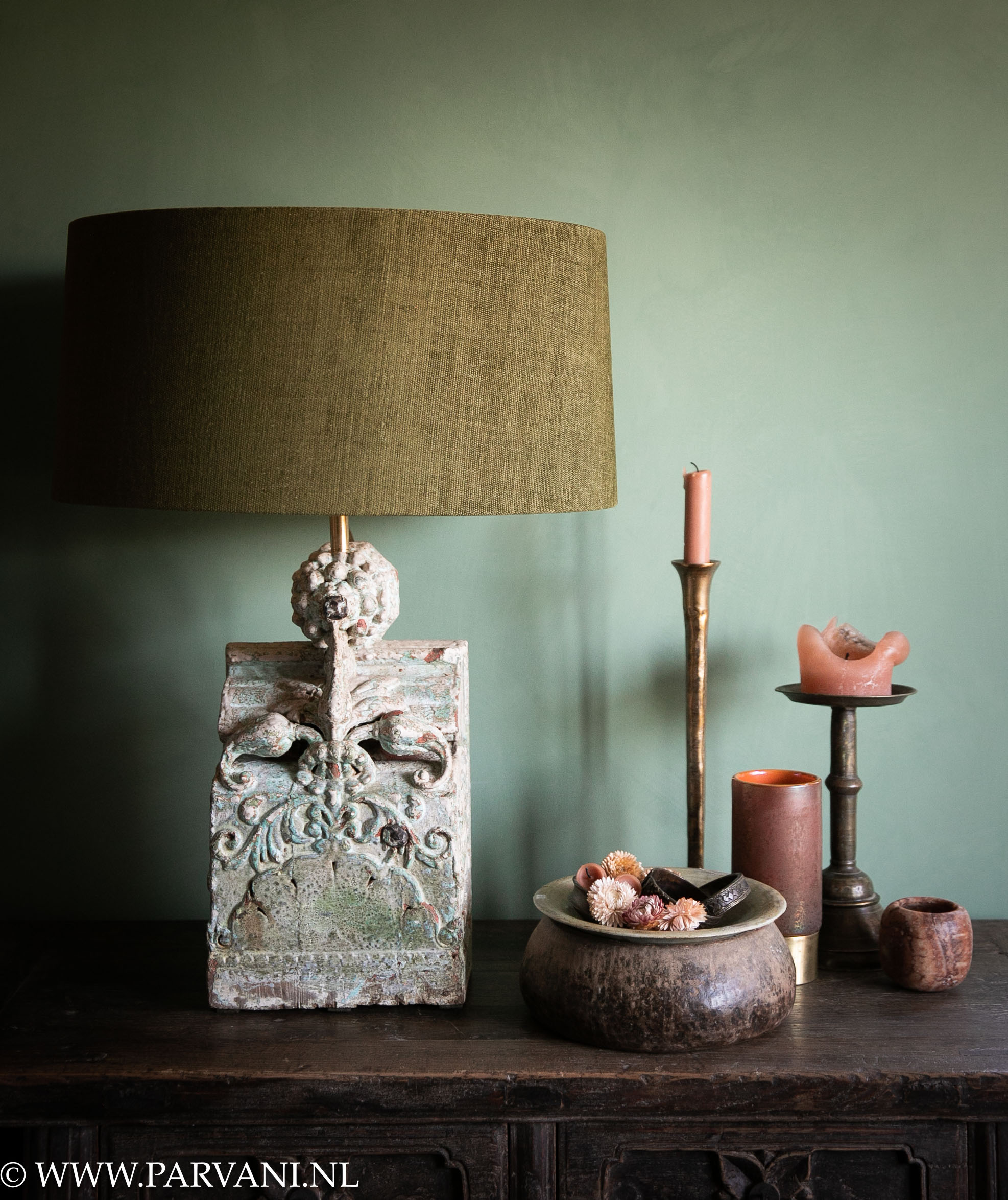 Unieke tafellamp van oud Indiaas ornament met snijwerk blauw groene tinten, mosgroene linnen lampenkap en woonaccessoires in warme roze oranje kleuren