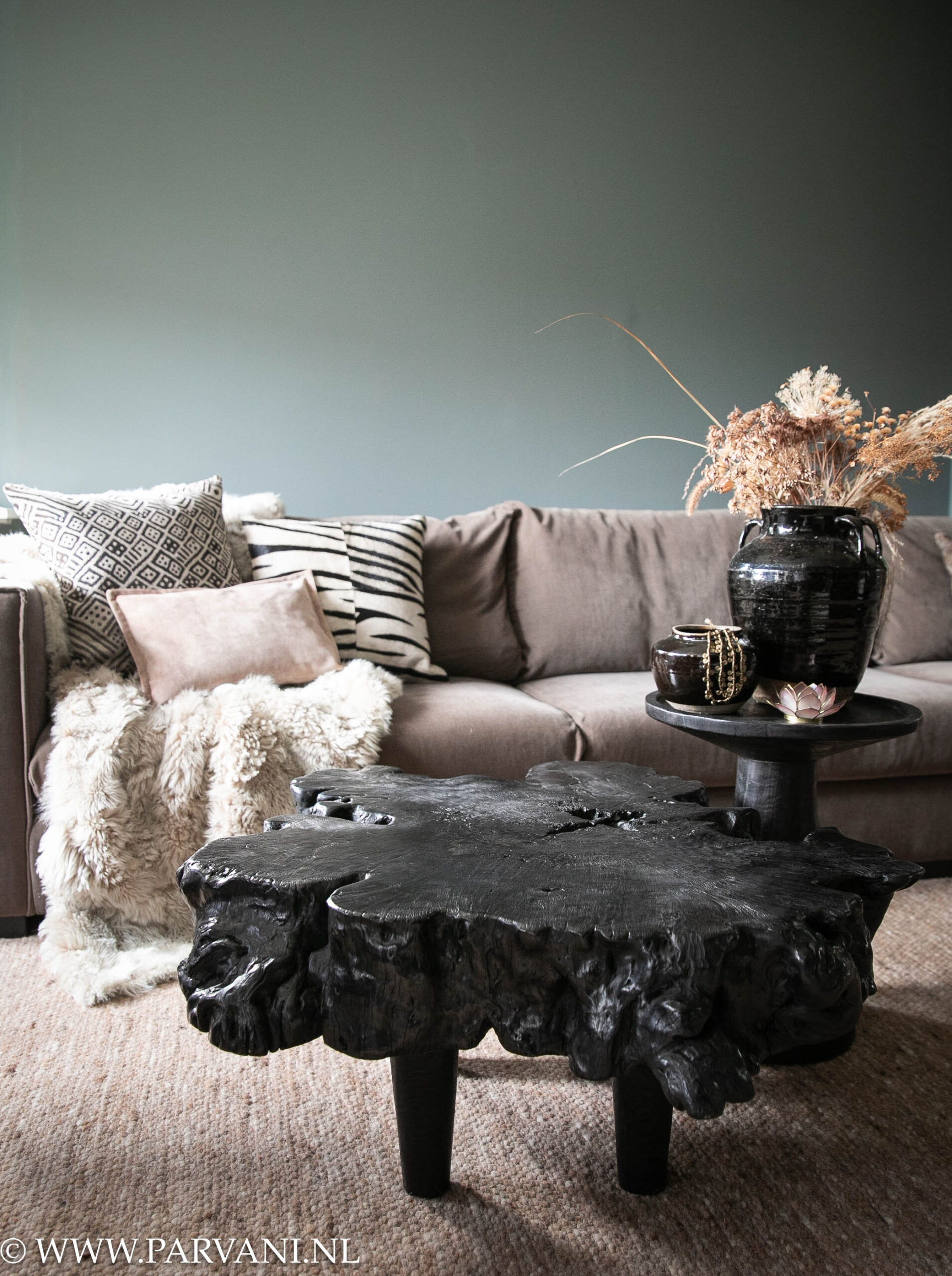 Grillige stoere zwarte lychee houten boomstam salontafel met ronde houten bijzettafel uit Indonesië en zwart wit roze kussens