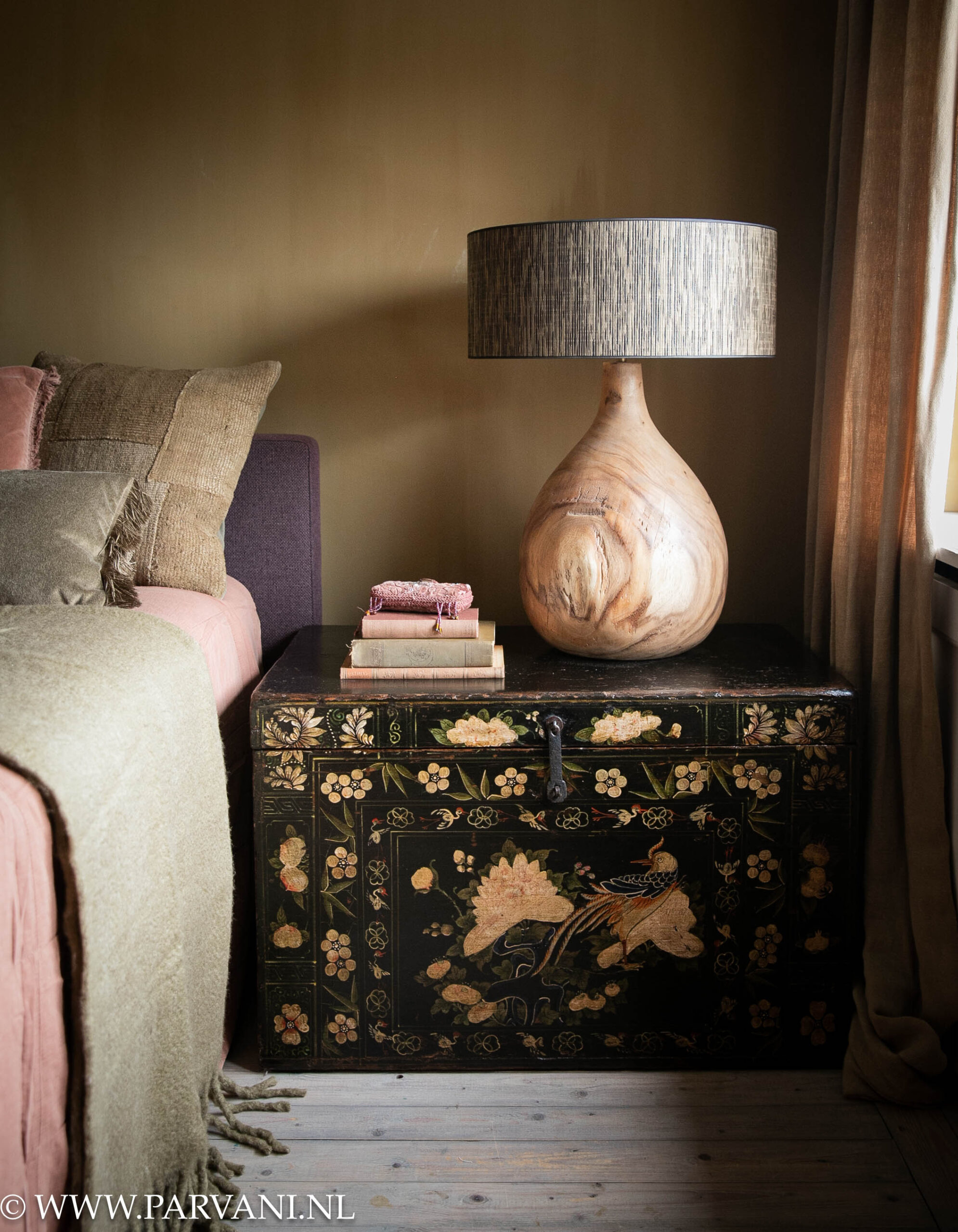 Grote zwarte Chinese kist beschilderd met vogels en bloemen in slaapkamer met mosterd kleurige kalkverf muur