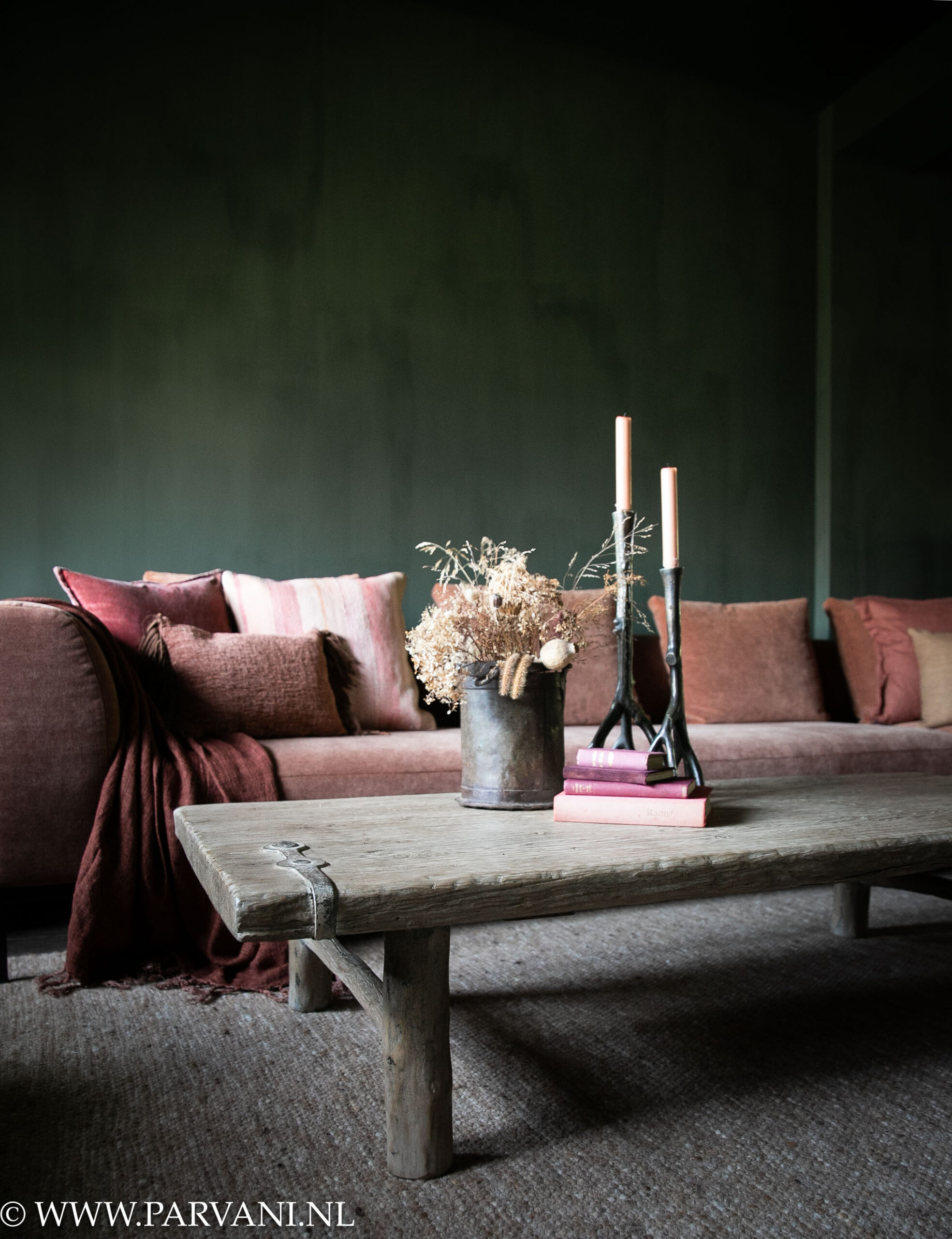 Langwerpige houten salontafel gemaakt van oude deur met metaalbeslag in lichte kleur en met mooi geleefd blad