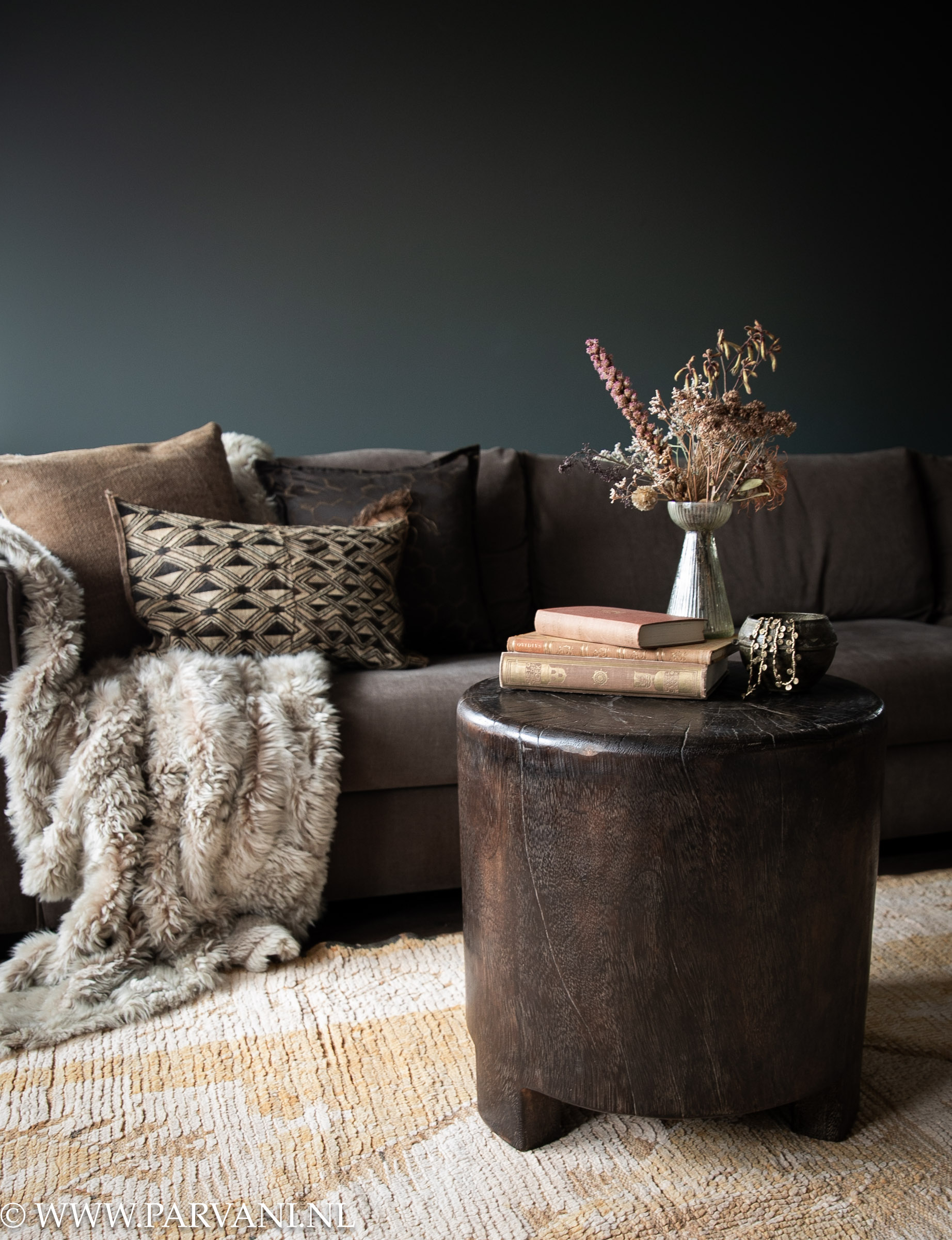 Stoere ronde houten bijzettafel in donkerbruine kleur bij zithoek