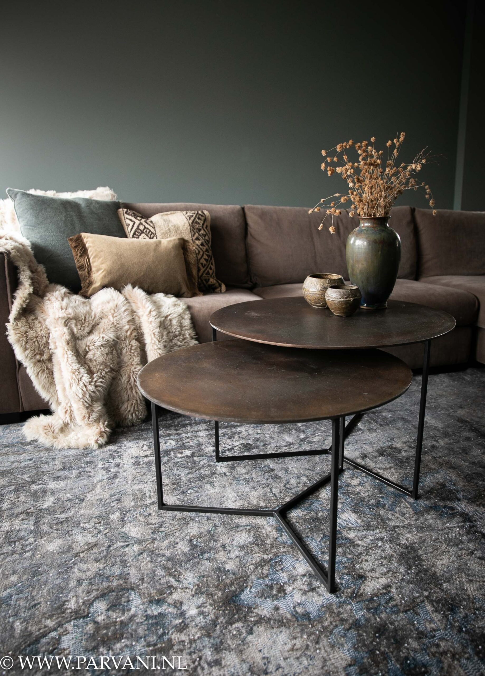 Set ronde salontafels in brons koperkleur met zwart onderstel op groot bruin met blauw vintage tapijt