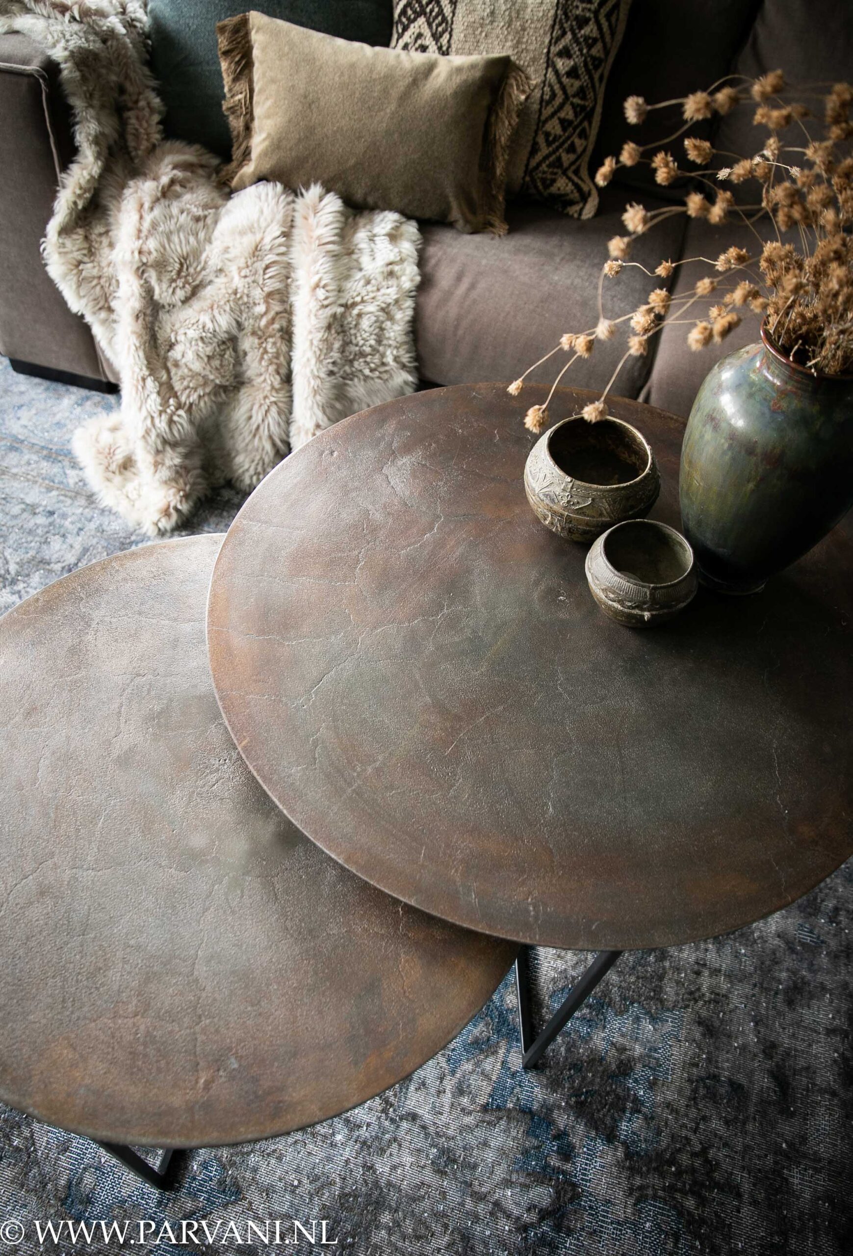 Set ronde salontafels in brons koperkleur met zwart onderstel op groot bruin met blauw vintage tapijt