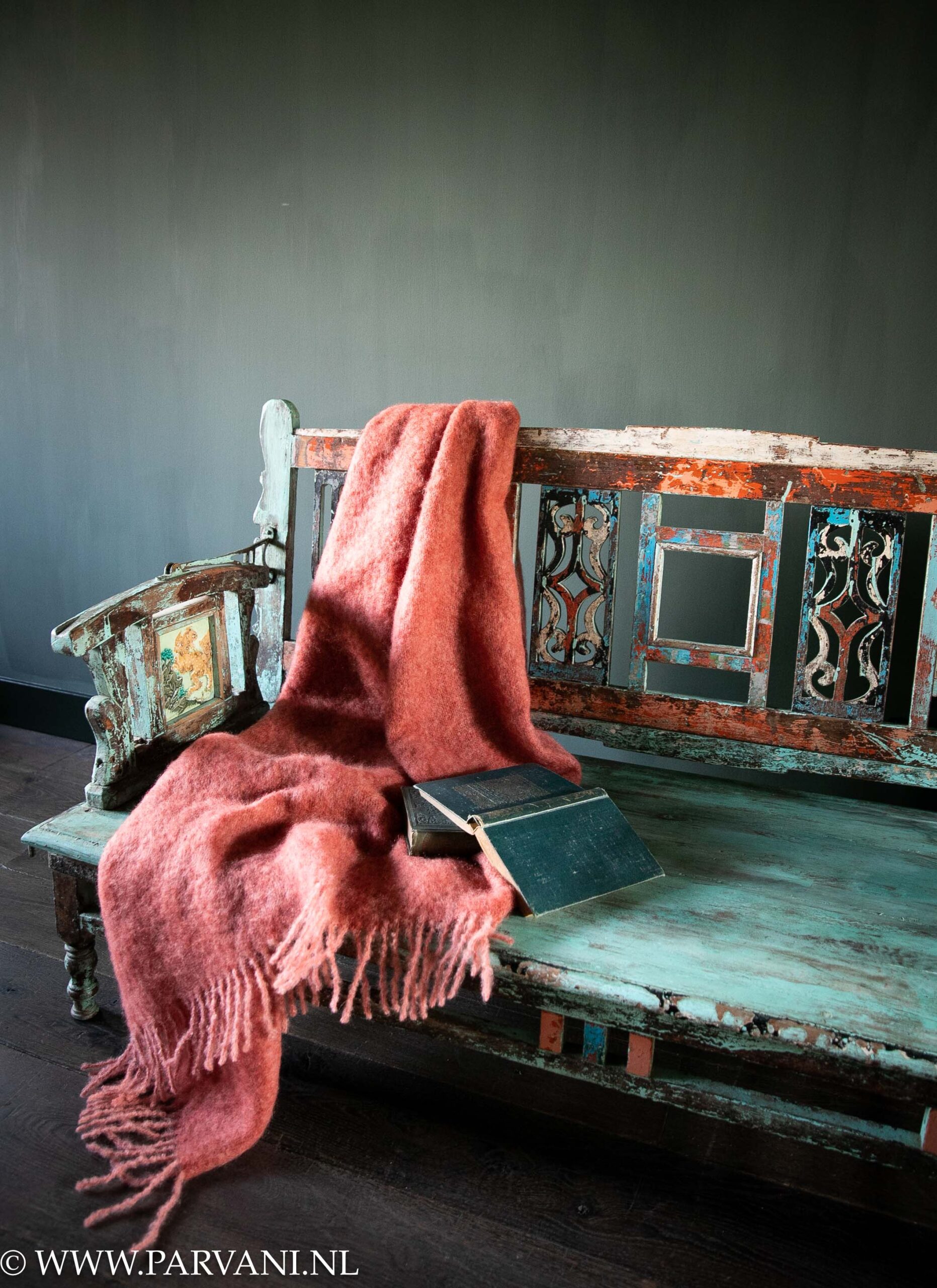 Kleurrijk uniek oud houten bankje uit India met tegeltjes en kleuren turquoise, blauw en oranje met luxe koraal roze mohair wollen plaid