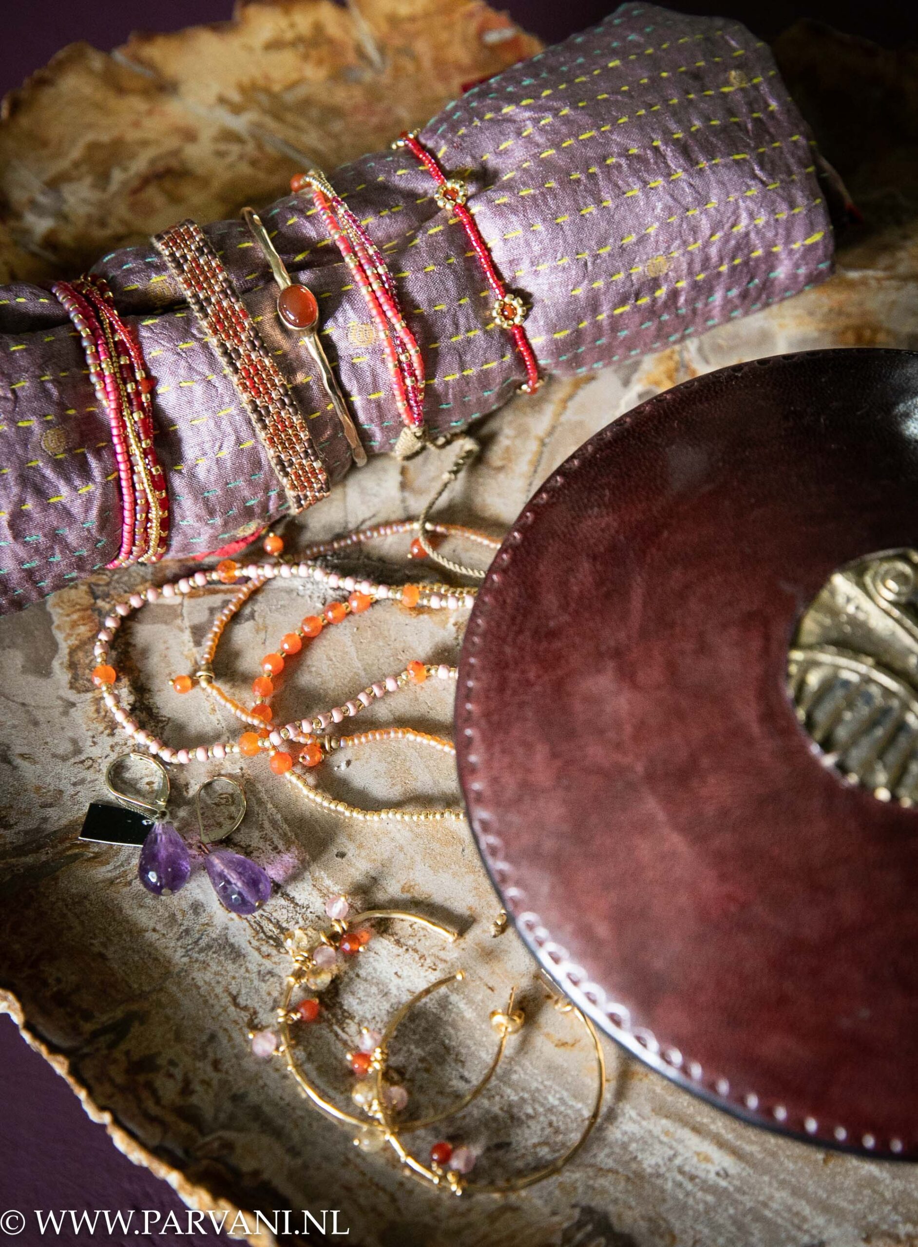 Fairtrade sieraden met armbanden en oorbellen in warme kleuren paars roze en oranje